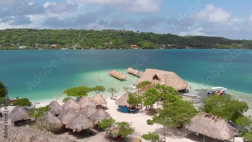 Aerial panoramic view flying over El Cholon island with bungalows and a nice tropical beach, in Baru, Islas del Rosario, Cartagena, Colombia