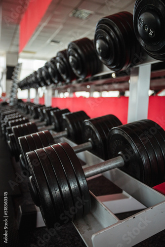 Rack with heavy dumbbells in the gym or fitness club.