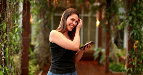 Beautiful smiling young woman outside using cellphone