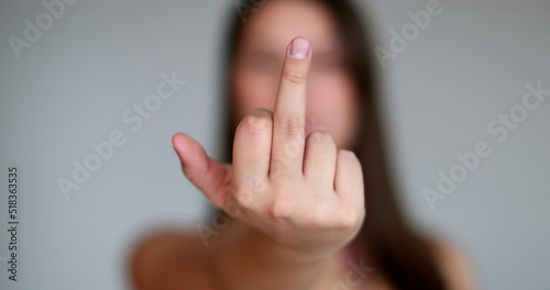 Angry young woman giving the middle finger to camera