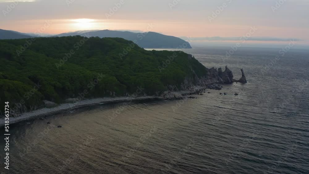Sea stack vertically sticking out of the water at dawn. Drone view, panoramic view. Cape Laplace, East Sea Sea stack vertically sticking out of the water at dawn. Drone view, panoramic view. Cape Laplace, East Sea