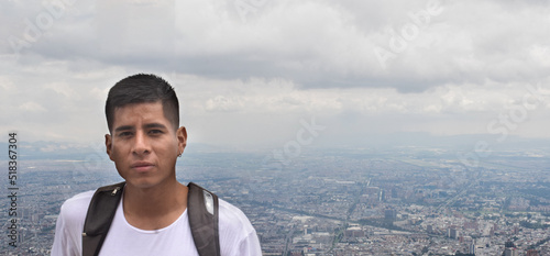 Joven en la cima de una montaña y con la ciudad vista desde el cerro de Monserrate en Bogotá, Colombia