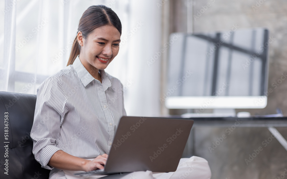 Happy Asian teen girl using laptop computer on the sofa, Smiling young woman using apps, shopping online, reading news, browsing the internet. Happy Asian teen girl using laptop computer on the sofa, Smiling young woman using apps, shopping online, reading news, browsing the internet.