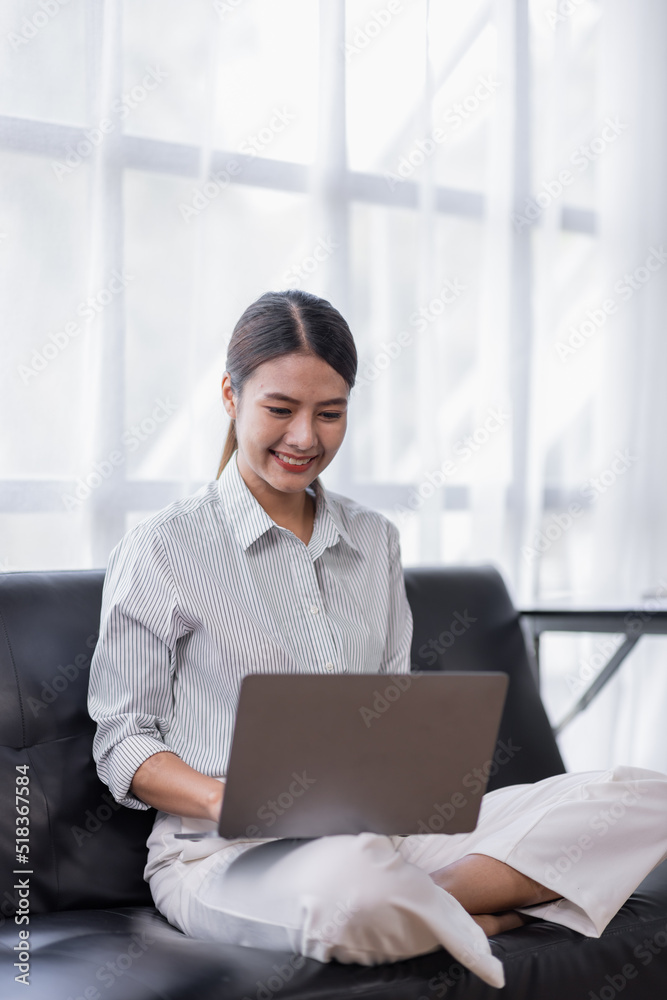 Happy Asian teen girl using laptop computer on the sofa, Smiling young woman using apps, shopping online, reading news, browsing the internet. Happy Asian teen girl using laptop computer on the sofa, Smiling young woman using apps, shopping online, reading news, browsing the internet.