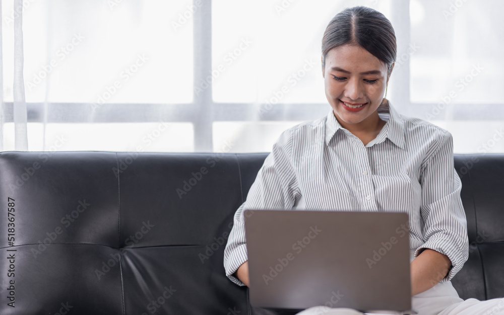 Happy Asian teen girl using laptop computer on the sofa, Smiling young woman using apps, shopping online, reading news, browsing the internet. Happy Asian teen girl using laptop computer on the sofa, Smiling young woman using apps, shopping online, reading news, browsing the internet.