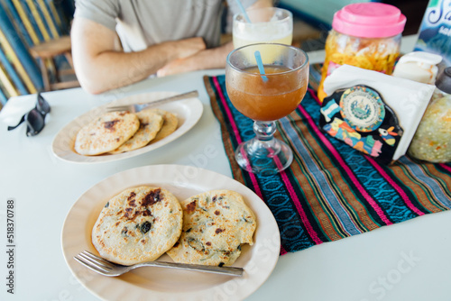 Plates of papusas and large cups of juice on a table in Belize photo