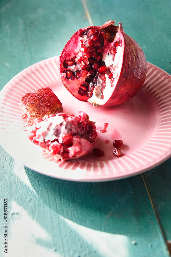 Red pomegranate and blue wooden background Red pomegranate and blue wooden background