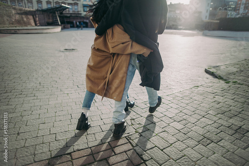 young couple having fun under the coat on ste streets
 photo