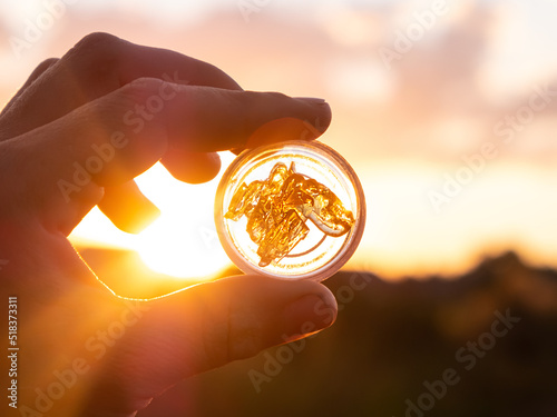 cannabis wax extract in container on sunset background, marijuana dab smoking mood.