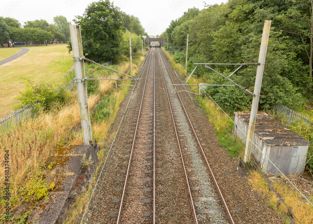 Fototapeta premium train tracks at longport station going of to the distance towards stoke on trent showing the Overhead line equipment shot from above