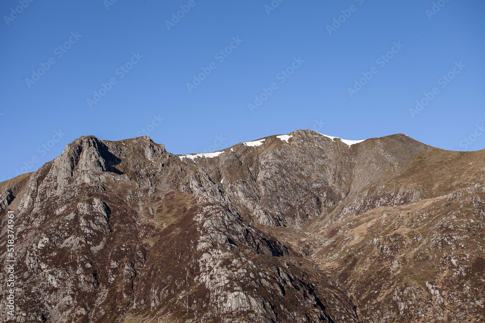 mountain peak at a mountain ridge under a clear blue sky mountain peak at a mountain ridge under a clear blue sky