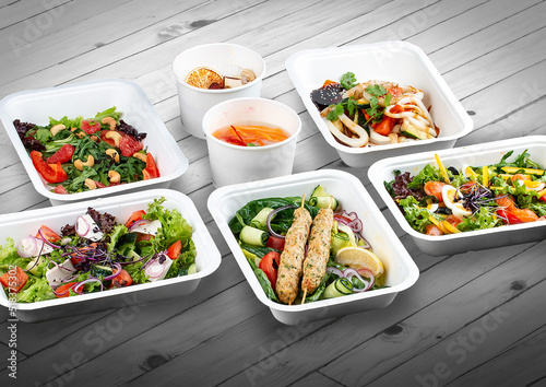 A set of healthy food dishes in ecological packaging on a wooden background. Food delivery. Takeaway.