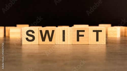 word SWIFT written on wooden cube block stack on black background, business concept