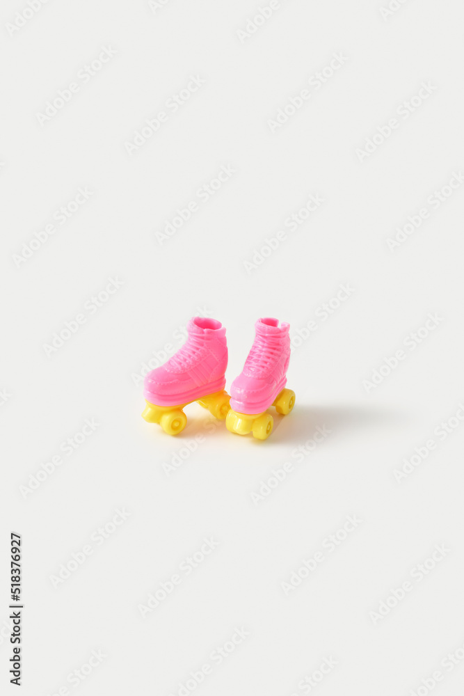 Miniature pair of doll rollers standing on grey background Miniature pair of doll rollers standing on grey background