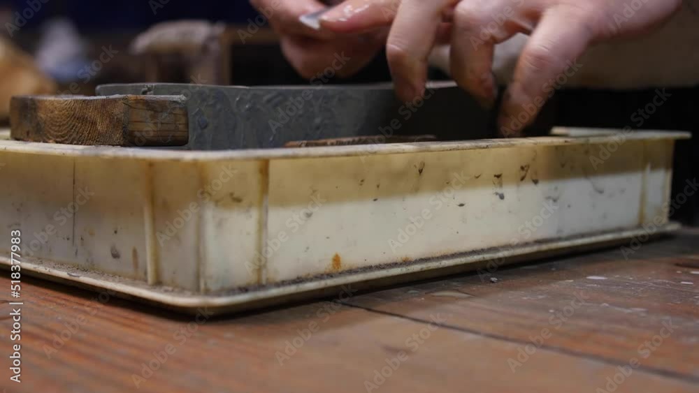 Master swordsmith is sharpening knife on grindstone with water Master swordsmith is sharpening knife on grindstone with water