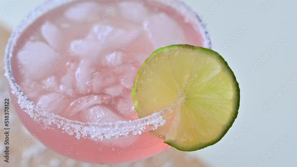 Glass of pink margarita drink with ice and lemon Glass of pink margarita drink with ice and lemon