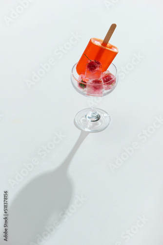 Glass of refreshing drink with ice cubes and berries photo