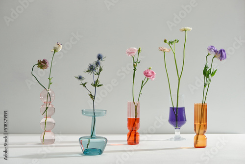 Glass vases with beautiful bouquets of fresh flowers photo