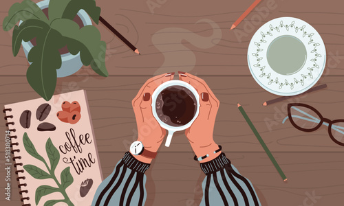 Female hands holding mug of coffee on wooden table background with