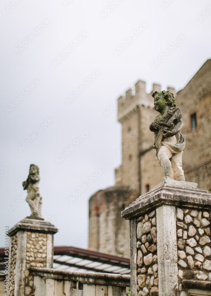 Stone sculptures of angels with violins on the turrets of the castle Orsini - Odescalchi in Nerola, Rome.
