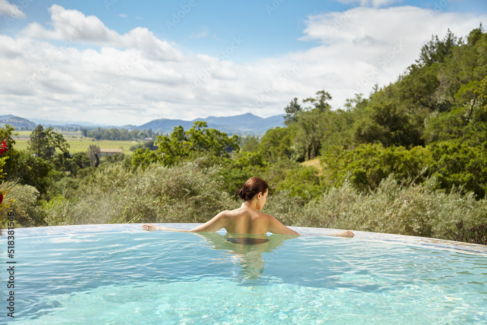 Woman soaking in hot tub pool on vacation in California Woman soaking in hot tub pool on vacation in California