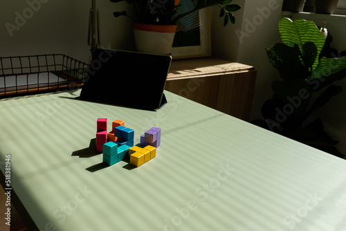 Colored cubic puzzle on desk a sunny day photo