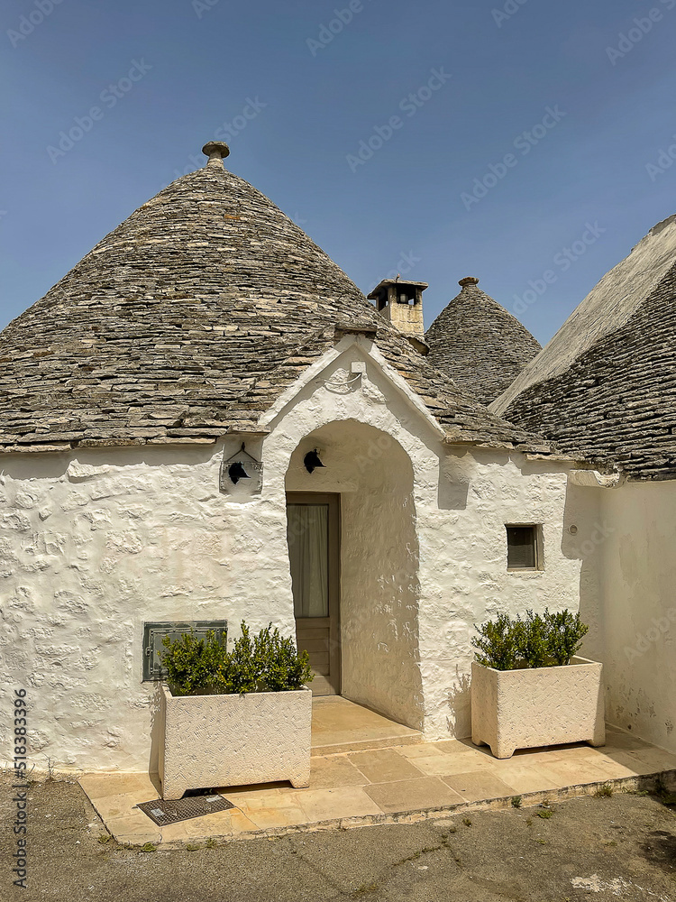 Alberobello, Italy, Apulia region Trullo buildings, Trulli of Alberobello UNESCO, trullo detailed with horizontal stone conical roof and front entrance flanked by potted plants