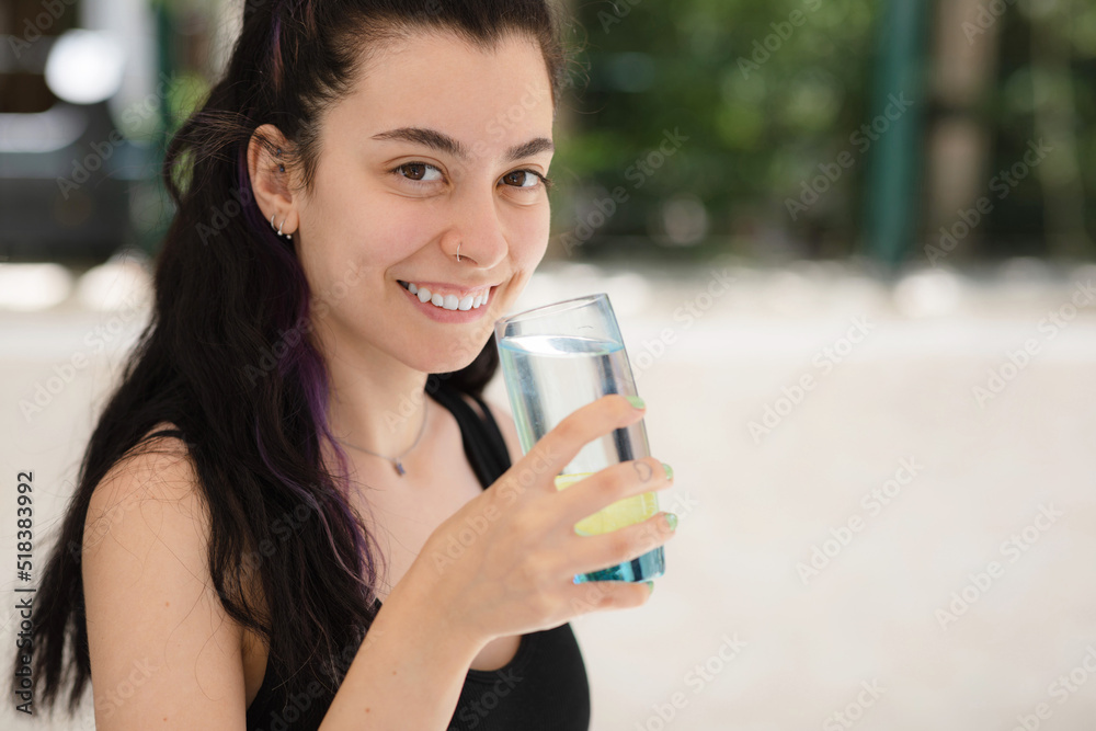 Young woman drinking lemon water outdoor and looking at camera Young woman drinking lemon water outdoor and looking at camera