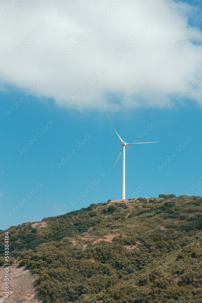 a wind turbine on a monatia, in the background of the blue sky a wind turbine on a monatia, in the background of the blue sky