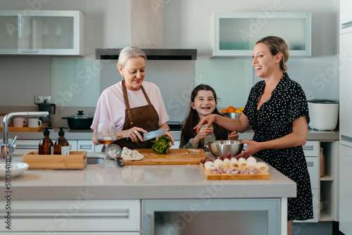 Female family cooking together at kitchen photo