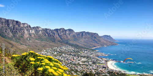 Landscape of a mountain range near a coastal city against a blue horizon in summer, South African. Wide angle wallpaper of The twelve apostles near calm sea and popular travel location for copy space photo