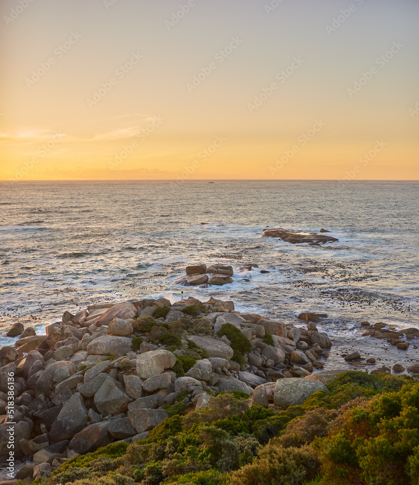 Copyspace landscape of an ocean view against a sunset sky in summer. Beautiful and calm scenery from the beach seaside while the sun sets in the distance. Natural environment of the sea at dawn