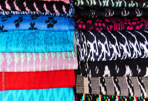 Scarves or Macanas at the market, traditional handcraft and design for Gualaceo canton, Azuay province, made by using technique called Ikat, colorful fabrics background. Cuenca, Ecuador	 photo