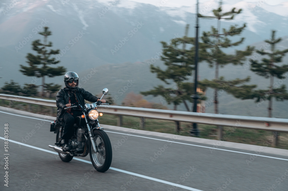 Male biker driving motorcycle in highlands Male biker driving motorcycle in highlands