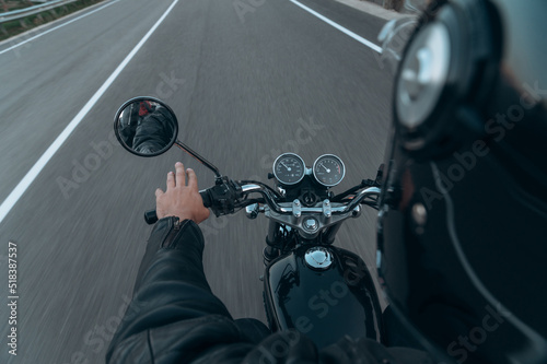 Crop man driving fast motorcycle on road