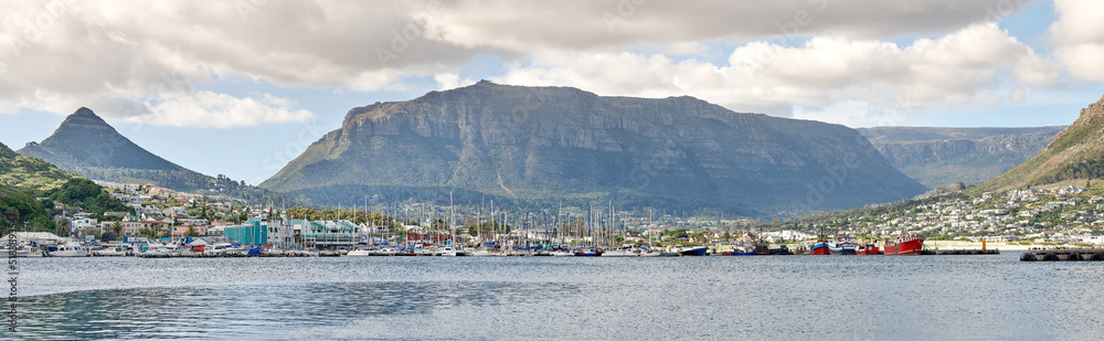 Beautiful view of the ocean and cloudy blue sky with Table mountain in the background. Peaceful ocean seascape with copy space and urban buildings close to the harbor in Cape Town, South Africa