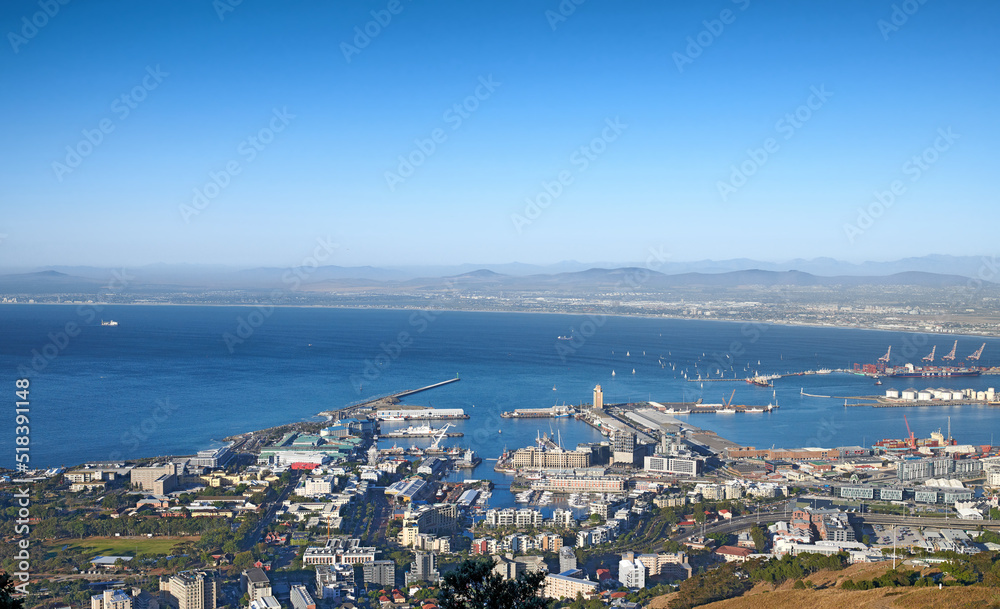 Aerial view of a city and ocean with harbor in Cape Town during the day. Scenic landscape view of a small port, urban buildings and seascape against a blue sky with copy space in South Africa