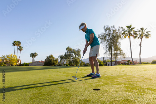 Senior Citizen on putting green on Golf course in morning  photo