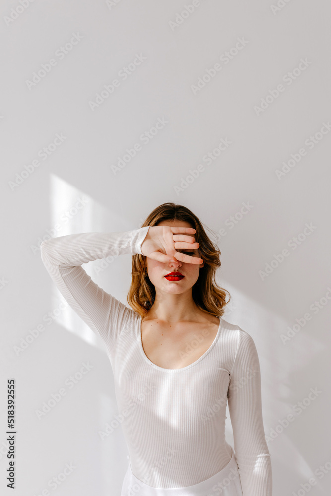 Female model covering face from sunlight Female model covering face from sunlight