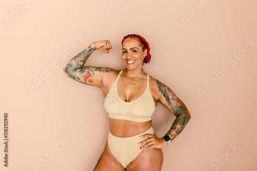 Muscular woman with tattoos flexing bicep