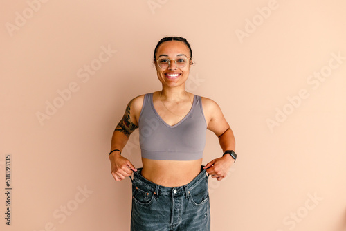 Smiling hispanic woman in bra and jeans photo