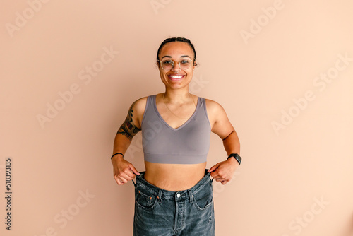 Smiling hispanic woman in bra and jeans