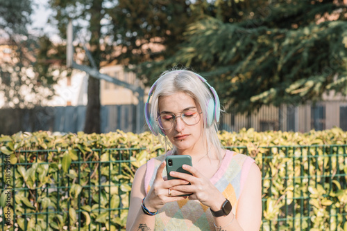 Young Woman Holding Smartphone In Urban Surroundigs photo
