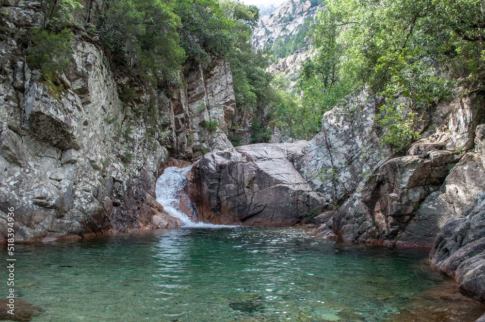 Turquoise blue clear water in the lake. Cascades on a rock with a waterfall. Cascades de Polischellu - France. Turquoise blue clear water in the lake. Cascades on a rock with a waterfall. Cascades de Polischellu - France.