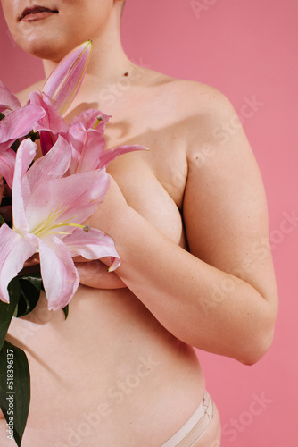 Anonymous nude woman with pink flowers photo