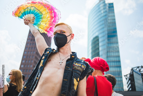 Man with a rainbow hand fan during Pride photo