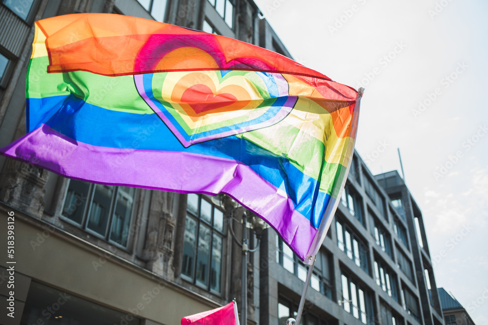 Rainbow love Pride flag with a heart waving during Pride in the city ...