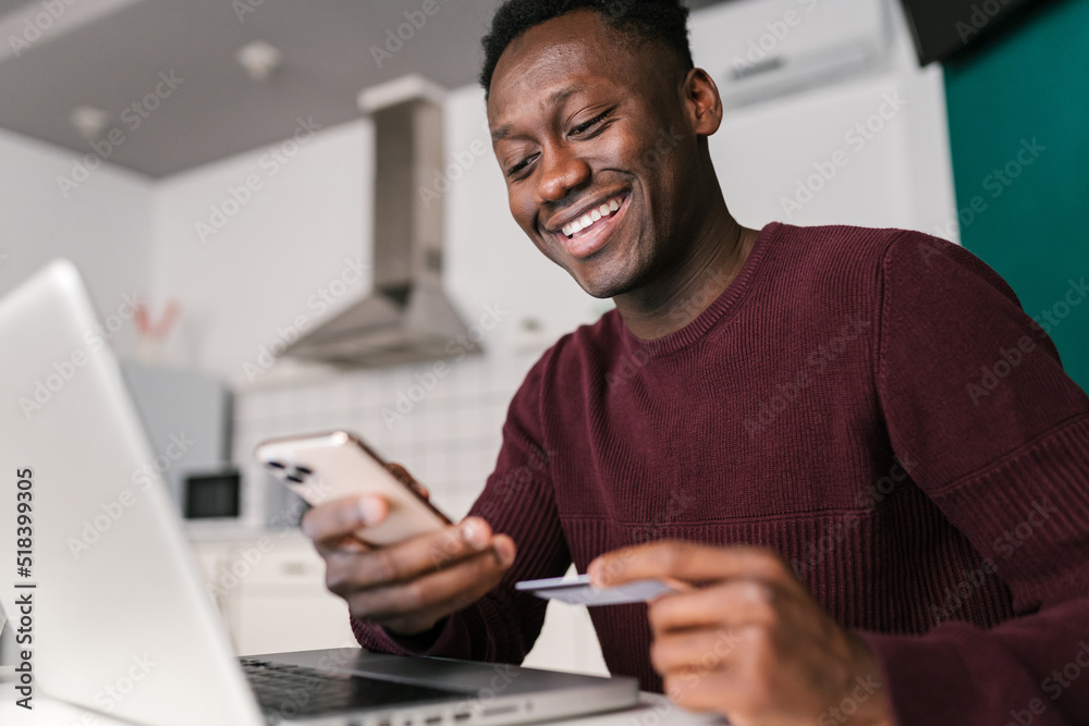 Glad black man browsing online store application Glad black man browsing online store application