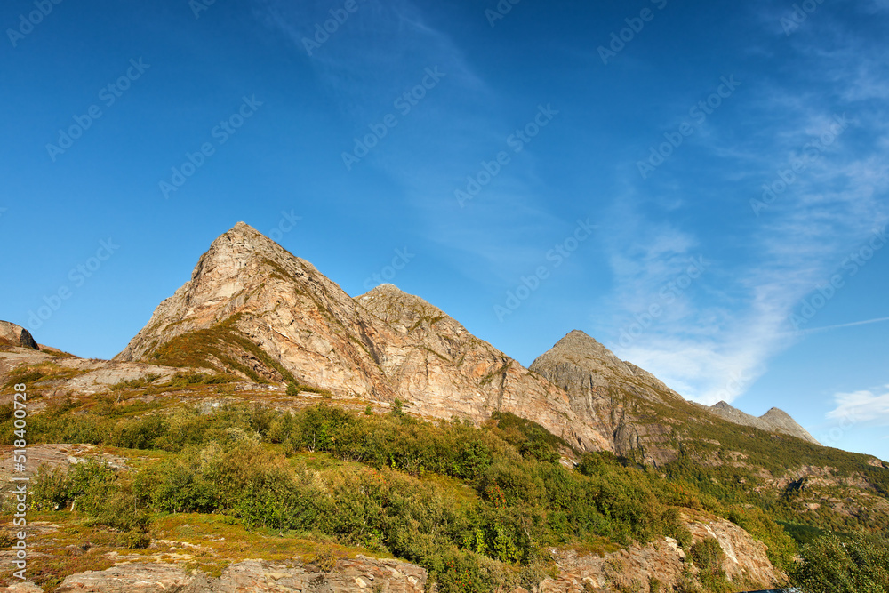 Scenic landscape of mountains against a blue sky background with copy space. Majestic view of plants growing on a rocky hill and cliff in nature. A beautiful travel destination and tourist attraction