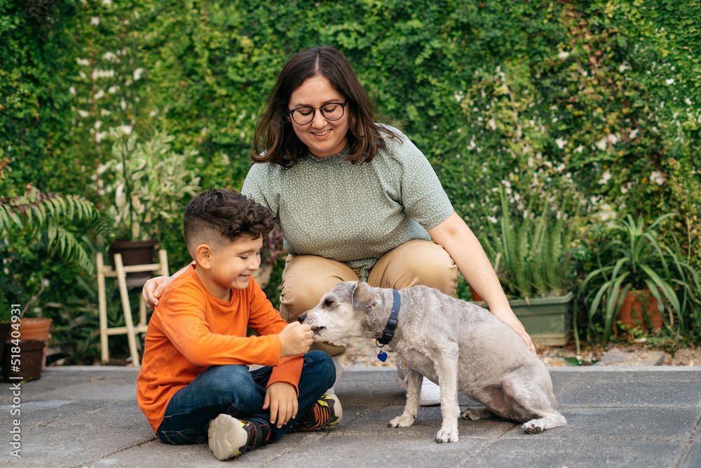 A young teaching a kid how to train his dog A young teaching a kid how to train his dog